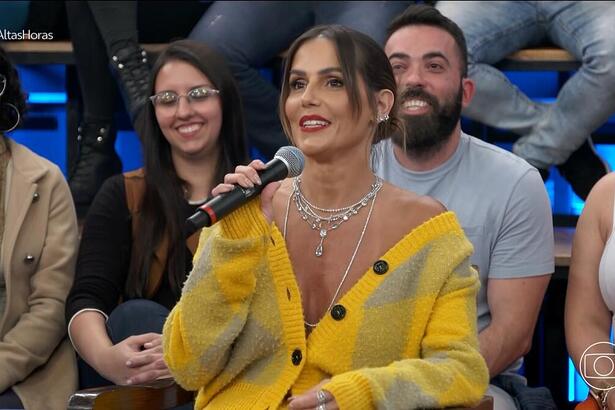 Deborah Secco de blusa amarelo segurando o microfone do Altas Horas