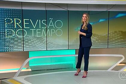 Jaqueline Brasil comandando a Previsão do Tempo com o fio caído na frente do telão