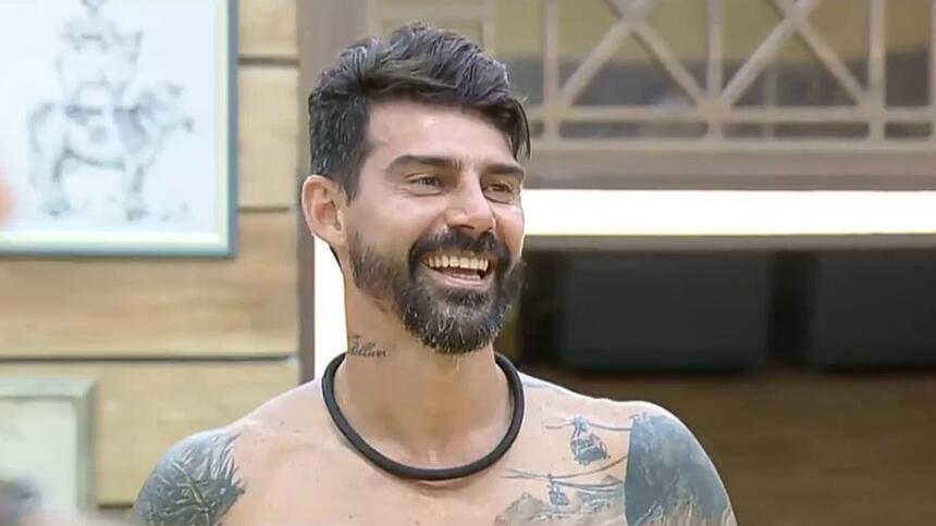 Radamés sorrindo na cozinha após dizer que criou bordão em A Fazenda