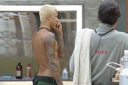 WL em pé ao lado de André que está com uma toalha pendurada n o braço.