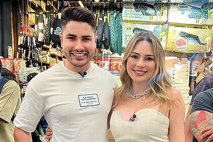 Lucas Souza ao lado de Rachel Sheherazade em um mercado de São Paulo. Os dois estão sorrindo