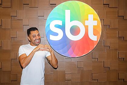 Tirulipa faz coração com a mão em frente ao logo do sbt