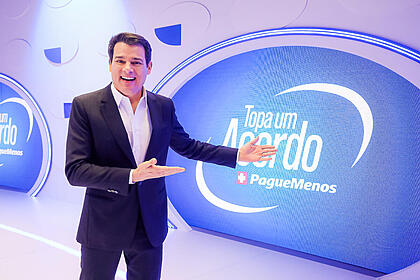 Celso Portiolli aponta para o logo do Topa um Acordo