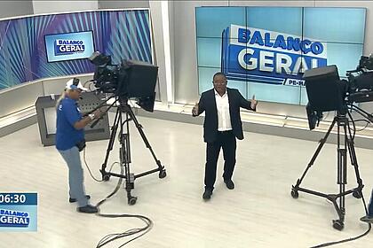 Evenilson Santana com os braços abertos no meio das câmeras do Balanço Geral Manhã PE