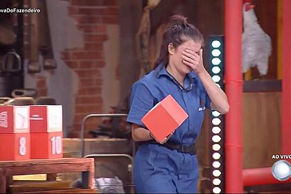 Jaquelline segurando uma caixa vermelha durante Prova do Fazendeiro