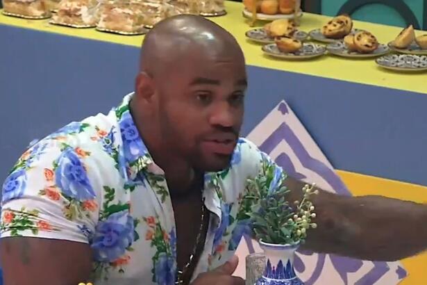 Cezar Black sentado, olhando para Radamés, enquanto conversa com o peão na Festa de A Fazenda 15