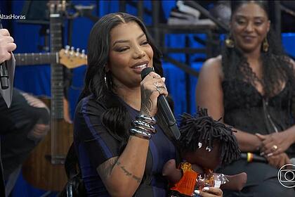 Ludmilla segurando presente do seu bebê no Altas Horas