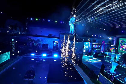 Belo de roupa azul, em cima de uma estrutura, voando na festa do BBB 24