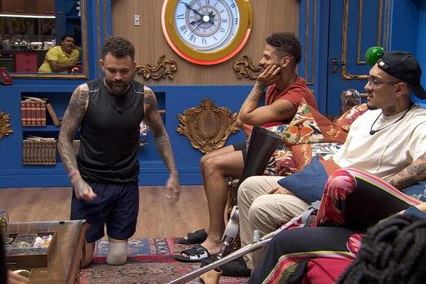 Vinicius Rodrigues de joelhos e simulando um ato sexual na sala do bbb 24