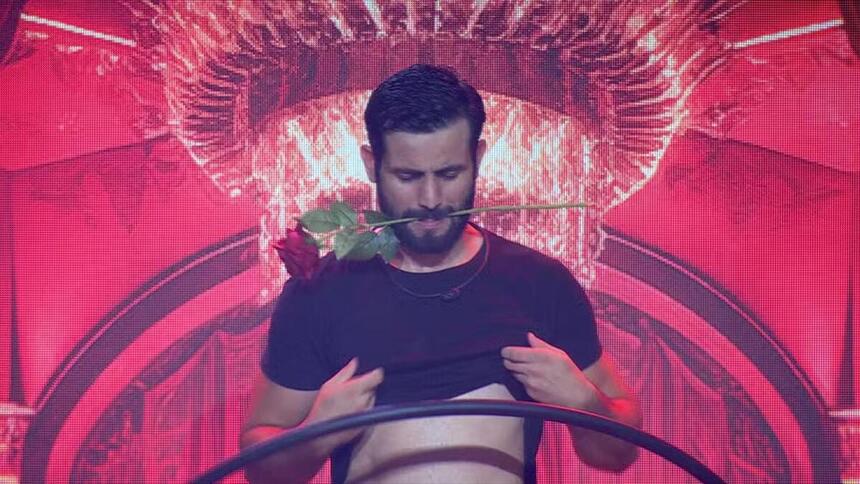 Matteus com uma rosa na boca e sensualizando na festa do BBB
