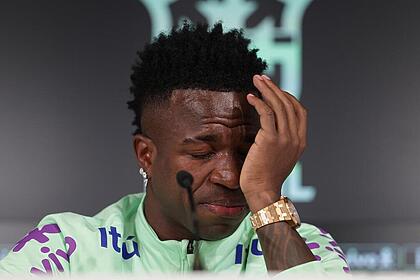 Vinicius Jr. com a mão no rosto e chorando na coletiva da Seleção Brasileira