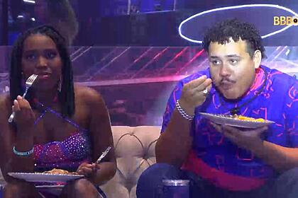 Lucas com o garfo na boca ao lado de Leidy