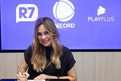 Rachel Sheherazade usa blusa preta e está sorrindo ao assinar contrato com a Record