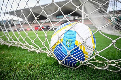 Bola dentro de um gol na rede de um jogo de futebol