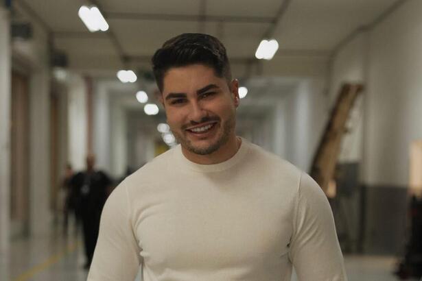 Lucas Souza sorrindo no corredor do SBT