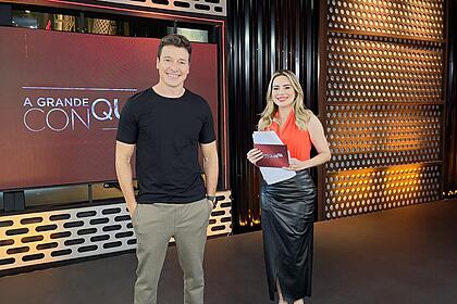 Rodrigo Faro ao lado de Rachel Sheherazade no cenário do A Grande Conquista 2