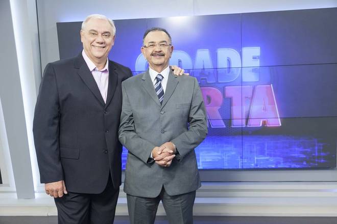 Marcelo Rezende sorrindo ao lado de Percival de Souza no Cidade Alerta