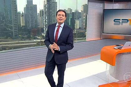 Alan Severiano sorrir enquanto anda pelo cenário do SP1 na TV Globo São Paulo