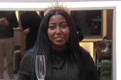 Edlaine com uma taça na mão na suíte das donas em a grande conquista