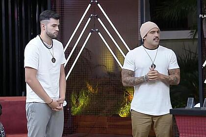 Kaio e joão hadad vestem camisa branca e estão um ao lado do outro conversando com rachel sheherazade na prova dos donos do a grande conquista 2