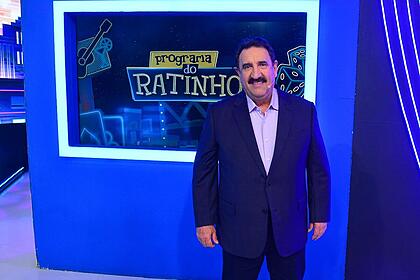 Ratinho sorrindo em frente ao logo do seu programa no SBT