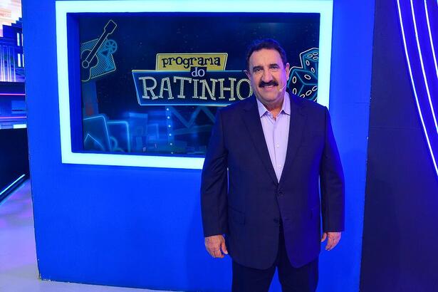Ratinho sorrindo em frente ao logo do seu programa no SBT