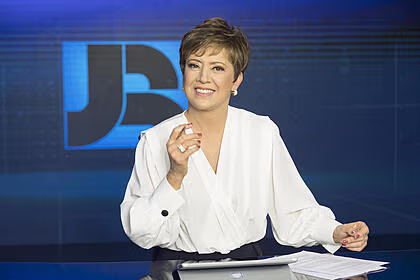 Christina lemos sorrindo na bancada do jornal da record