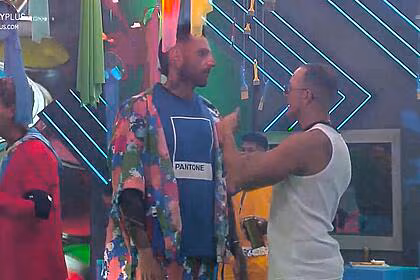 Guipa olha para fellipe no centro do palco da festa das cores, eles falam de dona geni no a grande conquista
