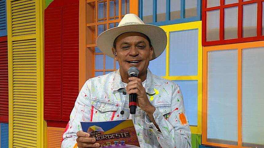 Frank Aguiar segura ficha e microfone na TV Aparecida