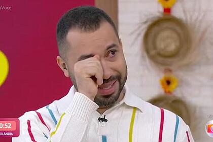 Gil do Vigor com a mão no rosto e emocionado no Mais Você