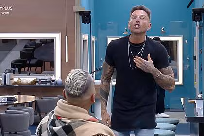 Brenno, sentado, com guipa em pé, na sua frente, em trecho de discussão na a grande conquista