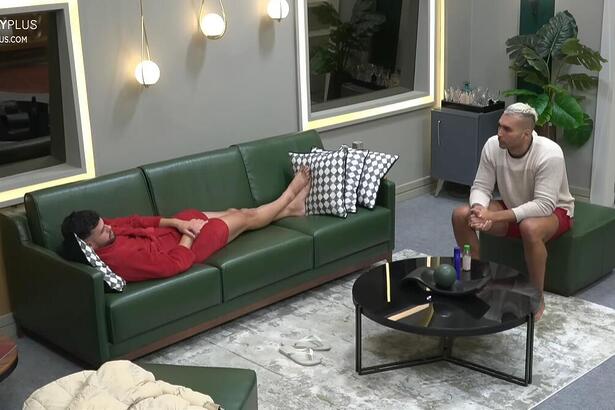 Kaio deitado no sofá e Brenno sentado a sua fente, em conversa na suíte dos Donos em A Grande Conquista