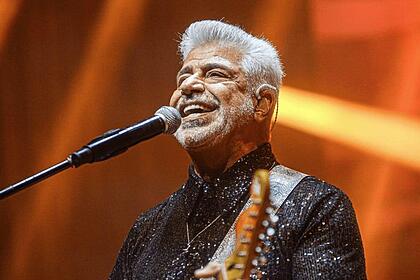 Lulu Santos durante um show tocando um instrumento