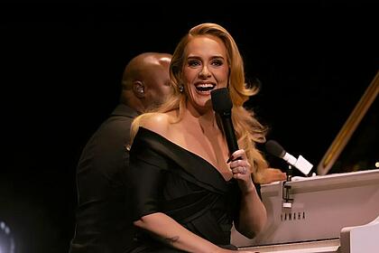 Adele sorrindo em apresenta&ccedil;&atilde;o ao lado de pianista