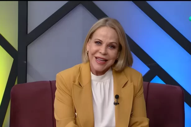 Claudete Troiano sorrindo sentada no sofá do seu programa na RedeTV!