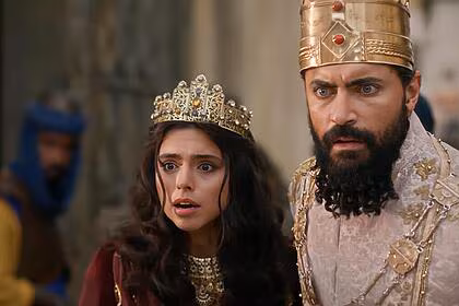 Ester assustada ao lado de xerxes em cena de a rainha da pérsia