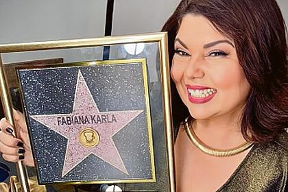 Fabiana Karla segura o quadro com a estrela na calçada da fama no SBT