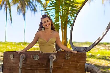 Fernanda Souza dentro de um baú em uma praia, gravando o reality show Ilhados com a Sogra da Netflix