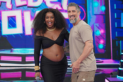 IZA sorrir e abraça Marcos Mion no centro do palco do Caldeirão