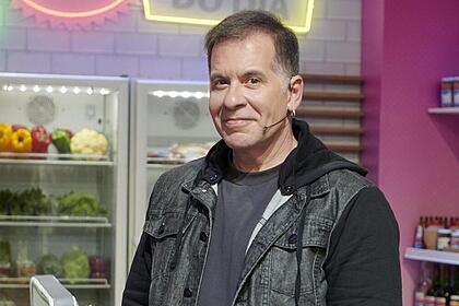 Leandro Hassum sorrindo, nos bastidores de um cozinha, em Minha Mãe Cozinha Melhor programa de TV
