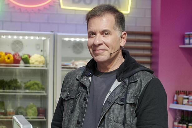 Leandro Hassum sorrindo, nos bastidores de um cozinha, em Minha Mãe Cozinha Melhor programa de TV