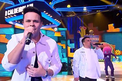 Matheus e Kauan cantando no palco do Caldeirão com Mion