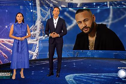 Carolina ferraz e sergio aguiar em frente ao telão do domingo espetacular com foto de neymar