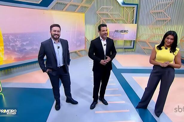 Felipe Malta, Darlisson Dutra e Daniele Brandi sorrindo no cenário do Primeiro Impacto
