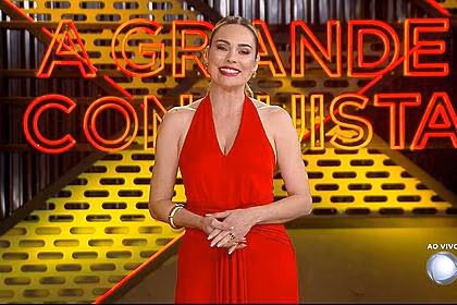Rachel sheherazade de vermelho sorrindo no cenário do a grande conquista 2