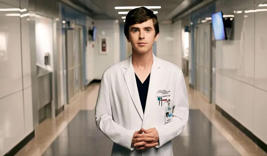 A imagem mostra o Dr. Shaun Murphy usando um jaleco branco em corredor de hospital.