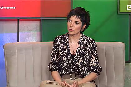 Glória vanique com samblante sério sentada no sofá de o programa de todos os programas