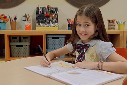 Anna em uma banca de escola na chamada de A Caverna Encantada