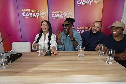 Grupo Pixote e a empresária Sylvia Design sorriem durante gravação do quadro Cadê Minha Casa?