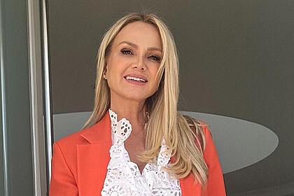 Eliana de casaco laranja indo para a coletiva de imprensa do seu novo programa na Globo